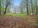 Secluded backyard featuring a white home and a lush green lawn surrounded by mature trees at 25 Beechnut Ct, Franklinton, NC 27525
