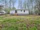 Expansive backyard featuring a white home with a patio and a lush green lawn surrounded by mature trees at 25 Beechnut Ct, Franklinton, NC 27525
