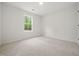 Bright bedroom with plush neutral carpet and a large window overlooking a lush, green landscape at 25 Beechnut Ct, Franklinton, NC 27525