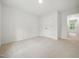 Spacious bedroom featuring plush neutral carpet, a closet, and natural light streaming in through the window at 25 Beechnut Ct, Franklinton, NC 27525
