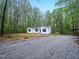 Charming front exterior of a home, featuring gravel driveway and lush greenery at 25 Beechnut Ct, Franklinton, NC 27525