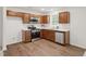 Modern kitchen features stainless steel appliances, wooden cabinets, white countertops, and wood-look flooring at 25 Beechnut Ct, Franklinton, NC 27525