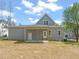 Rear view of a gray two-story home with a covered back porch and a spacious backyard at 250 Pilot Ridge Rd, Zebulon, NC 27597
