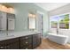Spa bathroom featuring a double vanity, soaking tub, and ample natural light at 250 Pilot Ridge Rd, Zebulon, NC 27597
