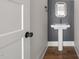 Elegant powder room with a pedestal sink, decorative mirror, and modern fixtures at 250 Pilot Ridge Rd, Zebulon, NC 27597