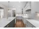 Modern kitchen boasts an island with a quartz countertop, white cabinetry, stainless steel appliances, and hardwood floors at 250 Pilot Ridge Rd, Zebulon, NC 27597