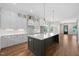 Bright kitchen featuring a spacious island with quartz countertop, white cabinets, and stainless steel appliances at 250 Pilot Ridge Rd, Zebulon, NC 27597