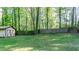 View of the back yard featuring a wooden storage shed and a wooden fence at 2700 Ross Rd, Durham, NC 27703