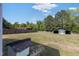 Expansive backyard featuring a storage shed, fencing, and lush green lawn under a bright, partly cloudy sky at 283 Raynor Rd, Spring Lake, NC 28390
