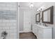 Well-lit bathroom with double sink vanity, white cabinets, and wood-look floors at 283 Raynor Rd, Spring Lake, NC 28390