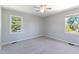 Neutral bedroom offers two windows, ceiling fan, and plush carpet at 283 Raynor Rd, Spring Lake, NC 28390