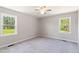 A bright bedroom features neutral paint, carpeted floor, and large windows with views of the backyard at 283 Raynor Rd, Spring Lake, NC 28390