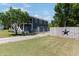 Two-story home with an attached garage, gravel driveway, and fenced backyard at 283 Raynor Rd, Spring Lake, NC 28390