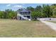 Two-story home with a large front yard and a gravel driveway at 283 Raynor Rd, Spring Lake, NC 28390