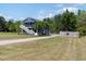 Exterior view of the two-story home with a screened-in porch, lawn, and gravel driveway at 283 Raynor Rd, Spring Lake, NC 28390
