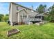 Expansive backyard showcasing a deck, screened porch, raised garden beds, and lush green grass at 3 Haycox Ct, Durham, NC 27713