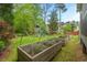 Spacious backyard with raised garden beds and play equipment, ideal for outdoor activities at 3 Haycox Ct, Durham, NC 27713