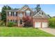 Charming two-story brick home with a well-manicured lawn, mature trees, and a two-car garage at 3 Haycox Ct, Durham, NC 27713