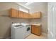 Well-lit laundry room featuring wooden cabinets, a sink, and a modern washer and dryer at 3 Haycox Ct, Durham, NC 27713