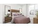 Stylish bedroom with a wood headboard, neutral color palette, and a large window for natural light at 3020 White Rail Dr, Fuquay Varina, NC 27526