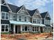 Modern townhomes featuring a stylish exterior with gabled roofs and large windows, in a new construction phase at 3020 White Rail Dr, Fuquay Varina, NC 27526