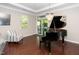 Bright living room with a piano, elegant chandelier, and sliding glass doors to the backyard at 3029 Willow Ranch Dr, Fuquay Varina, NC 27526