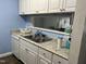 Bright kitchen featuring white cabinets, light countertops, and essential appliances, including a dishwasher and double sink at 303 Smith Level Rd # E32, Chapel Hill, NC 27516