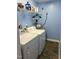 Functional laundry room with a washer and dryer, plus a hot water heater, set against blue walls and tiled floors at 303 Smith Level Rd # E32, Chapel Hill, NC 27516