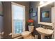 Powder room with dark grey walls, a round sink and a toilet next to a large window at 3100 Benton Cir, Raleigh, NC 27615