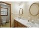 Bathroom featuring double sinks, framed mirrors and a doorway view to toilet and shower at 3121 Blue Hill Ln, Durham, NC 27703