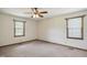 Bedroom with neutral carpet, ceiling fan, and natural light from two windows, creating a comfortable space at 3121 Blue Hill Ln, Durham, NC 27703