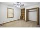 Bedroom features neutral carpet, a ceiling fan, natural light, and a built-in desk with shelving and drawers at 3121 Blue Hill Ln, Durham, NC 27703