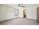 Spacious bedroom featuring neutral carpet, ceiling fan, natural light, and access to other rooms via doors at 3121 Blue Hill Ln, Durham, NC 27703