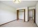 Bedroom features neutral carpet, natural light, access to a closet, and access to other rooms via doors at 3121 Blue Hill Ln, Durham, NC 27703