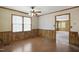 Dining room features wood floors, wood paneled walls, natural light from a window, and a ceiling fan at 3121 Blue Hill Ln, Durham, NC 27703