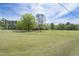 Expansive green yard showcases a well-maintained brick home beneath a cloudy sky at 3121 Blue Hill Ln, Durham, NC 27703