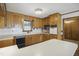 Traditional kitchen features wooden cabinetry, white countertops, black appliances, and access to additional rooms at 3121 Blue Hill Ln, Durham, NC 27703