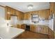 Traditional kitchen features wooden cabinetry, white countertops, black appliances, and a window over the sink at 3121 Blue Hill Ln, Durham, NC 27703