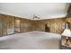 Large living room with paneled walls, a carpeted floor and a brick fireplace at 3121 Blue Hill Ln, Durham, NC 27703