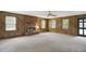 Cozy living room featuring a brick fireplace and ample natural light from large windows at 3121 Blue Hill Ln, Durham, NC 27703