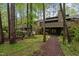 View of the back of the home surrounded by a wooded area and landscaped backyard at 33 Stoneridge Cir, Durham, NC 27705