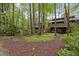 View of the back of the home surrounded by a wooded area and landscaped backyard at 33 Stoneridge Cir, Durham, NC 27705