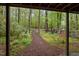 View of the lush backyard featuring a wooded area and a mulch path at 33 Stoneridge Cir, Durham, NC 27705