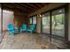 Covered stone patio with three blue chairs overlooking a wooded area at 33 Stoneridge Cir, Durham, NC 27705