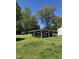 Large carport that can accommodate multiple vehicles surrounded by mature trees and ample greenery at 335 Ashley Ave, Timberlake, NC 27583