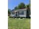 Charming home featuring mature landscaping, shutters, awning, and a brick chimney at 335 Ashley Ave, Timberlake, NC 27583