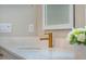 Bathroom sink with a gold faucet, white countertop, and an electric outlet on the wall at 353 Murray Grey Ln, Wake Forest, NC 27587