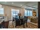Inviting dining area with a rustic wood table, patterned rug, and adjacent living area with large windows at 353 Murray Grey Ln, Wake Forest, NC 27587