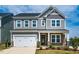 Charming two-story home featuring stone accents, a two-car garage, and a well-maintained front yard at 353 Murray Grey Ln, Wake Forest, NC 27587
