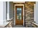 Close-up of a wood front door featuring decorative glass and stylish stonework at 353 Murray Grey Ln, Wake Forest, NC 27587